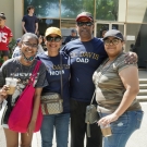 Four people stood in front of a building. The woman second from the left is wearing a UC Davis Mom T-Shirt, and the man to the right of her is wearing a UC Davis Dad T-Shirt.