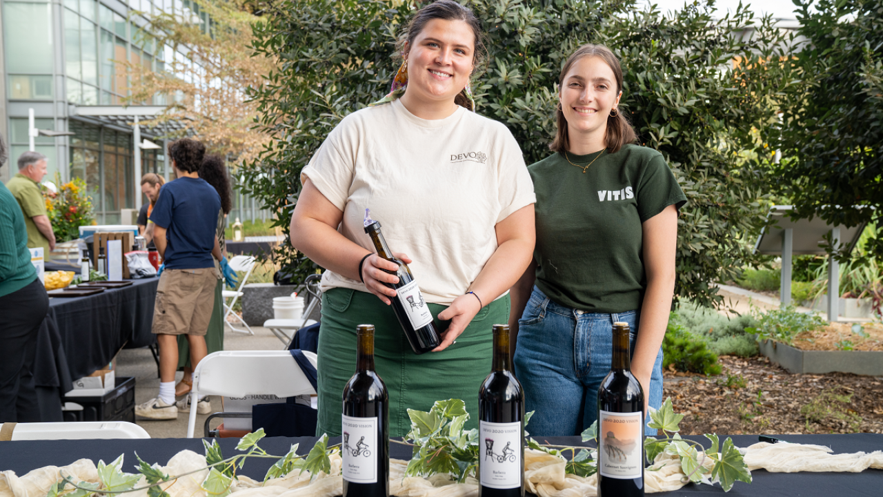 Two people holding a wine bottle