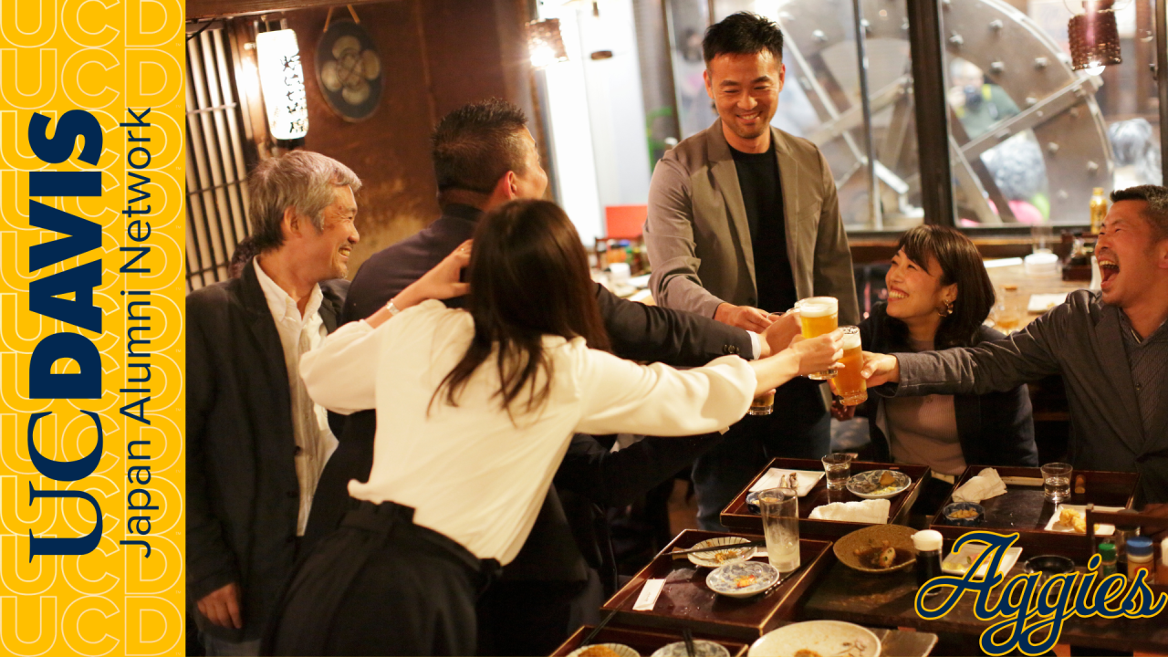 Photo of a group of people at a Japanese pub conducting a toast over some food. Paired with a banner that reads "UC Davis Japan Alumni Network"