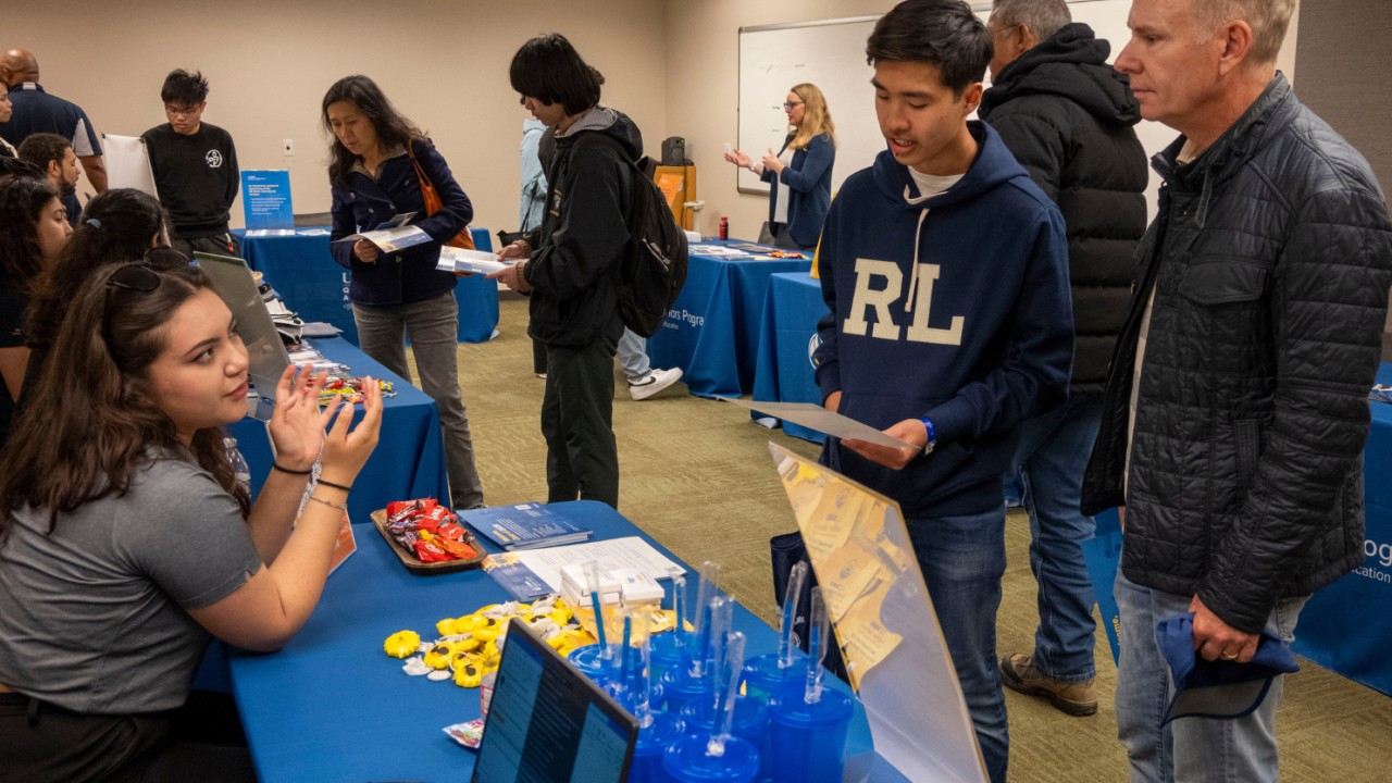 A student and their parent talk to a staff member about Summer Sessions