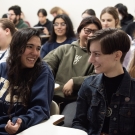 photo of a classroom at UC Davis. Students are seated in a lecture style room and the photo is focused on two students facing each other and conversing