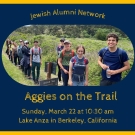 A group of people hiking on a trail surrounded by greenery.