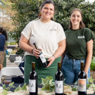 Two people holding a wine bottle