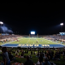 View of UC Davis Health from the endzone looking down the field during a night football game
