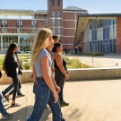 Tour guide speaking to a group in front of a brick building